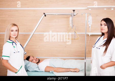 Patient im Krankenhaus Raum neben zwei Krankenschwestern Stockfoto