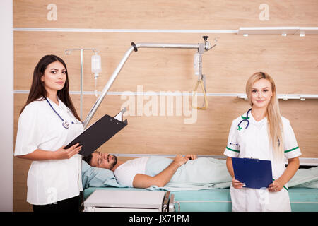Patient im Krankenhaus Raum neben zwei Krankenschwestern Stockfoto