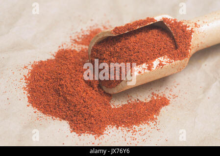 Getrocknete rote Chili im Messlöffel auf Papier Hintergrund Stockfoto
