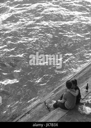 Zwei Liebende auf dem Ufer der Seine in Paris, Frankreich umfassen Stockfoto