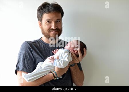 Onkel ihr zwei Wochen altes Baby girl Nichte zum ersten Mal halten. Stockfoto