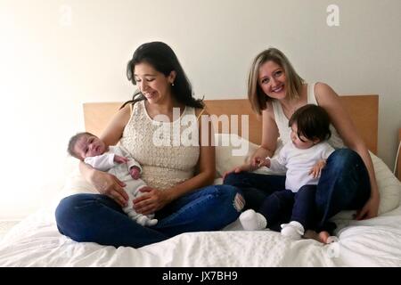 Mutter und Schwester-in-Gesetz ihr Baby Mädchen von zwei Wochen und zwölf Monaten Alt gedrückt halten. Stockfoto