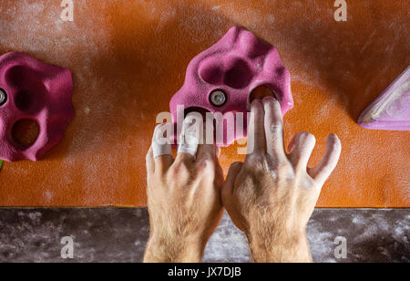 Nahaufnahme der Kletterer Hände greifen Haltegriff in der Kletterhalle Stockfoto