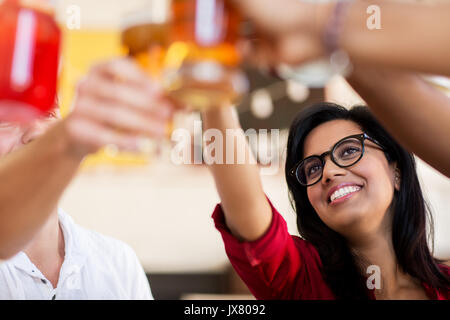 Freunde, die klirrende Gläser mit Getränken im restaurant Stockfoto