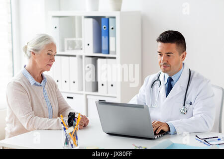 Ältere Frau und Arzt mit Laptop am Krankenhaus Stockfoto