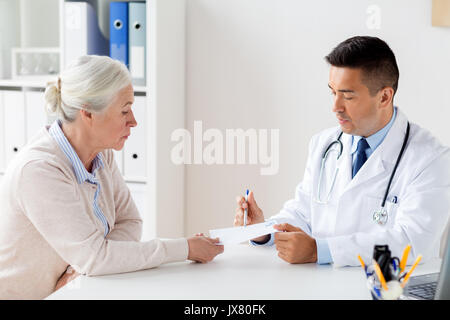 Frau und Arzt mit Rezept in Klinik Stockfoto