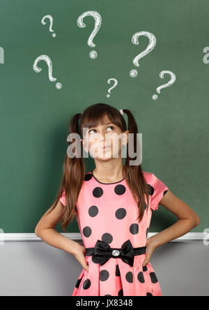 Kind mit Fragezeichen auf Schule Blackboard Stockfoto