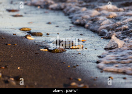 Ein in der Nähe der Lake Shore, mit Einzelheiten zu Luftblasen im Wasser und kleine Steine und Kiesel auf dem Sand Stockfoto