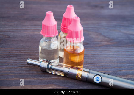 Eine elektronische Zigarette, eine vape und mehrere Flaschen Nachfllen von  Flssigkeiten fr liegen auf einem dunklen Hintergrund Stockfotografie -  Alamy