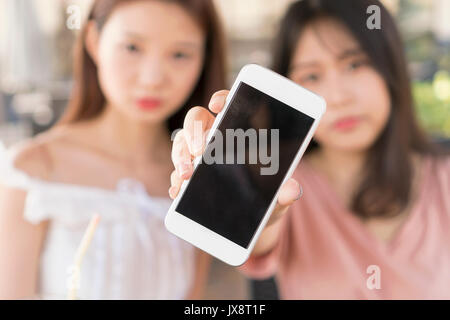 Zwei Mädchen mit Telefon Stockfoto