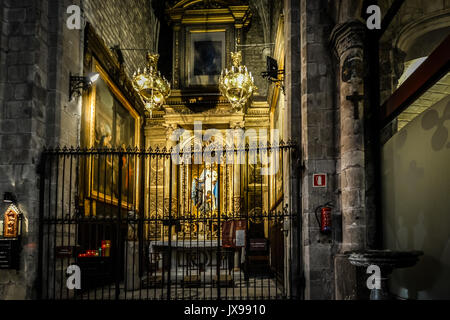 Kleine, dunkle gotische Altar in einer Kirche in Rom mit Kerzen beleuchtet und eine Statue der Jungfrau Maria Stockfoto