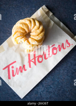 Ein Honig cruller Donut von Tim Hortons, einem beliebten Kanadischen fast food Restaurant und Donut Shop. Stockfoto