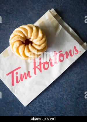 Ein Honig cruller Donut von Tim Hortons, einem beliebten Kanadischen fast food Restaurant und Donut Shop. Stockfoto