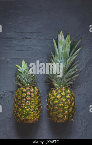 Zwei Ananas auf dunklem Hintergrund. Ansicht von oben kopieren Raum Stockfoto