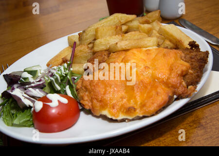 Huhn Parmo serviert zum Mittagessen in einem englischen Pub/Bar/Restaurant mit einem Pint Ale. Stockfoto