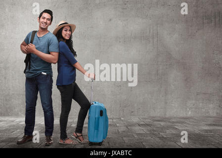 Jungen asiatischen Paar Tourist mit Gepäck warten Flug über grunge Hintergrund Stockfoto