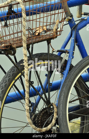 Zyklen links und gesperrt Radfahrer Fahrrad unbeaufsichtigt verlassen unter Verschluss Zyklen bei einem Zyklus rack Gefesselt für Sicherheit mit Hemet am Querträger Stockfoto