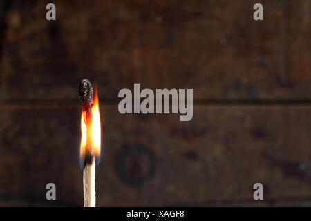 Nahaufnahme von einem brennenden Streichholz auf dunklem Hintergrund Stockfoto