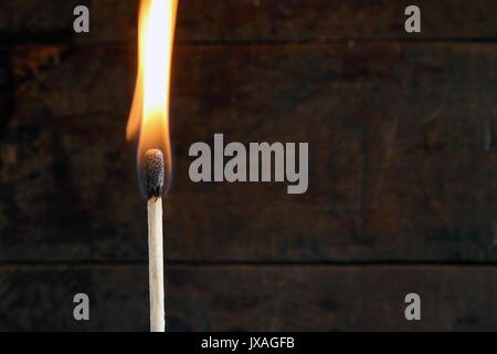 Nahaufnahme von einem brennenden Streichholz auf dunklem Hintergrund Stockfoto