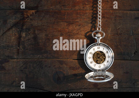 Zeit Konzept. Stilvolle Taschenuhr mit Kette gegen alte Holz- Hintergrund Stockfoto