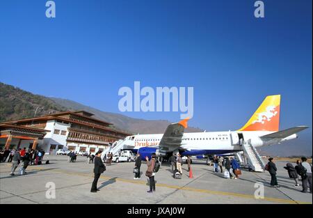 Thimpu, Bhutan - November 06, 2012: Nicht identifizierte Personen mit Gepäck zu Fuß und machen Fotos in Paro Flughafen nach der Landung mit einem Airbus A319 her Stockfoto