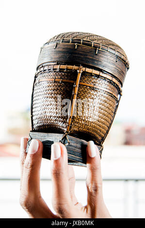 Woman's Fingern kleine Lao tingkop Warenkorb Stockfoto