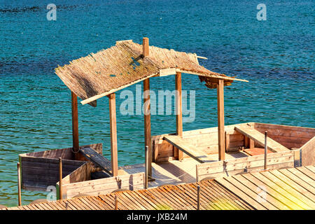 Boot Brücke mit einfachen Boot Haus oder Holzboot mit Strohdach. Stockfoto