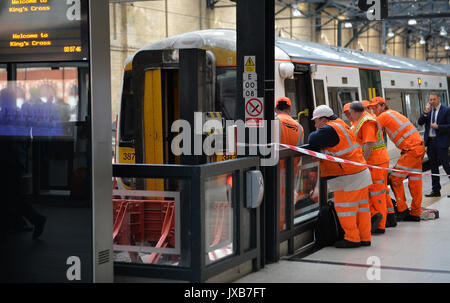 Der Mitarbeiter an der London Kings Cross Station Blick in den Zug von Royston schien der Puffer am Bahnsteig 9 zu schlagen. Stockfoto