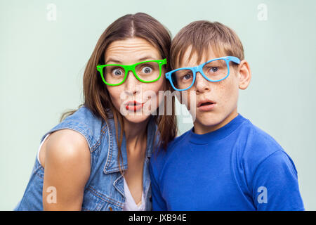 Familie, Emotionen und Gefühle. Ältere Schwester und ihrem Bruder mit Sommersprossen, über hellblauen Hintergrund zusammen auf Sommerzeit Posing, Kameras Stockfoto