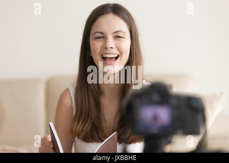 Positive lächelnde Frau mit Kamera, Aufnahme Buchbesprechung Stockfoto