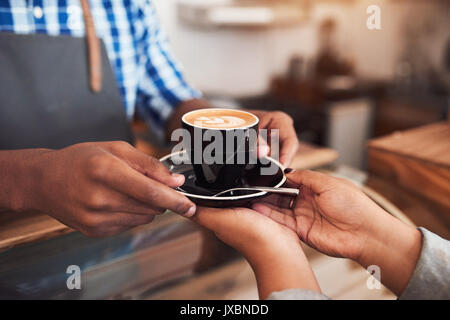 Barista Übergabe Kaffee in ein Cafe zu Kunde Stockfoto