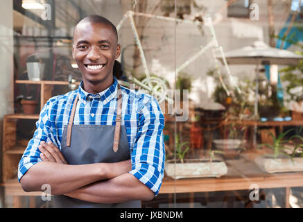Lächelnd afrikanische Unternehmer hinter einen Zähler von seinem Cafe stehend Stockfoto