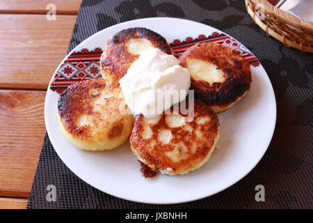 Syrniki - Quark Pfannkuchen, Krapfen von Hüttenkäse - traditionelle ukrainische und russische Küche. Stockfoto