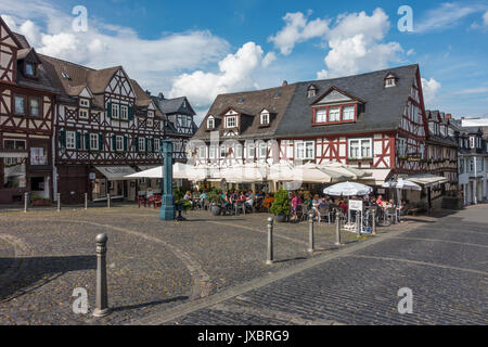 Marktplatz mit Fachwerkhäusern und historischen Wasserpumpe, die Gäste im Cafe unter Sonnenschirmen, Braunfels, Hessen, Deutschland Stockfoto