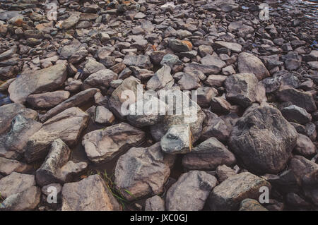 Grau glatte Steine im Fluss im Hintergrund. Stockfoto