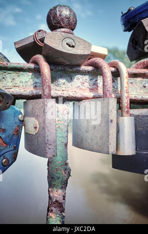 Retro stilisierte Bild der alten verrosteten Vorhängeschlössern auf einer Brücke, liebe Symbol, geringe Tiefenschärfe. Stockfoto