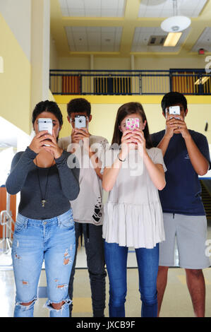 Teens Kids zu und starrte auf ihren Telefonen süchtig Stockfoto