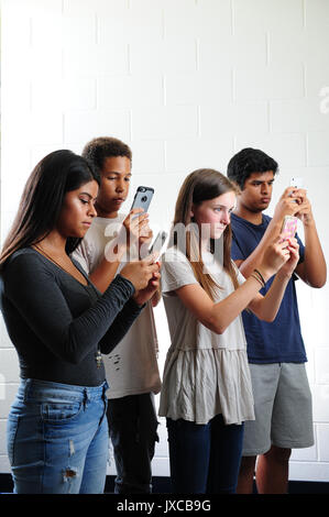 Teens Kids zu und starrte auf ihren Telefonen süchtig Stockfoto