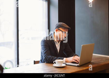 Schoß eines jungen Geschäftsmanns, der auf seinem Laptop in einem Café. Selektive konzentrieren. Stockfoto