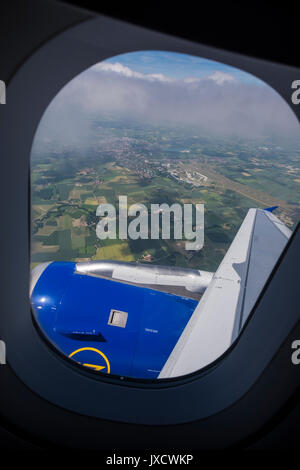 Auf grünes patchwork Felder durch ein Flugzeug bullauge Fenster kurz nach dem Start vom Flughafen München, Bayern, Deutschland Stockfoto