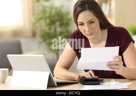 Aufmerksame Frau Berechnung der Buchhaltung in einem Schreibtisch zu Hause sitzen Stockfoto