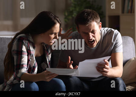 Wütend Paar lesen einen Brief auf einer Couch zu Hause sitzen Stockfoto