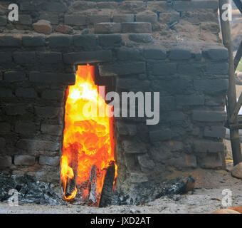 Nahaufnahme von einem Feuer in einem traditionellen Ziegel Brennofen mit Kokosnuss Schalen für Kraftstoff in Bali, Indonesien Stockfoto