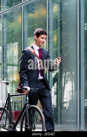 Junge zuversichtlich Mann Gespräch am Handy nach Fahrrad commutin Stockfoto