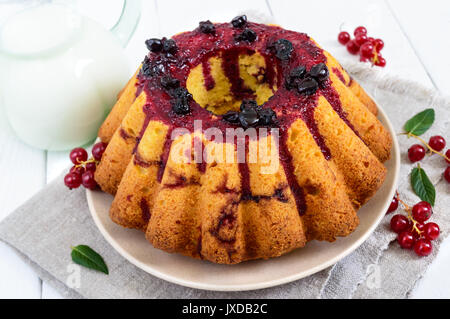 Frisch gebackene Kuchen mit Sommer Beeren, Kanne Milch auf weißem Hintergrund Stockfoto
