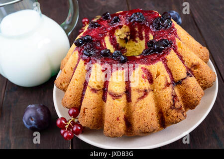 Große frisch gebackene Kuchen mit Sommer Beeren auf einem dunklen Holztisch. Stockfoto