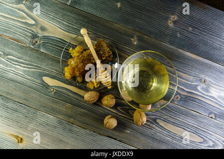 Honig mit wabe in einer Glasplatte auf alten Holztisch Stockfoto