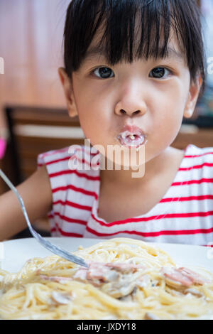 Asiatische chinesische Mädchen essen Spaghetti im Café im freien Stockfoto