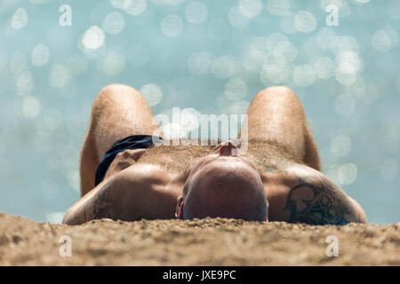 West Bay, Dorset, Großbritannien. 15 August, 2017. UK Wetter: Urlauber und Einheimische genießen Sie einen heißen sonnigen Nachmittag, Sonnenbaden und Schwimmen am Strand von West Bay. Foto Credit: Guy Corbishley/Alamy leben Nachrichten Stockfoto