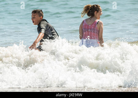 West Bay, Dorset, Großbritannien. 15 August, 2017. UK Wetter: Urlauber und Einheimische genießen Sie einen heißen sonnigen Nachmittag, Sonnenbaden und Schwimmen am Strand von West Bay. Foto Credit: Guy Corbishley/Alamy leben Nachrichten Stockfoto